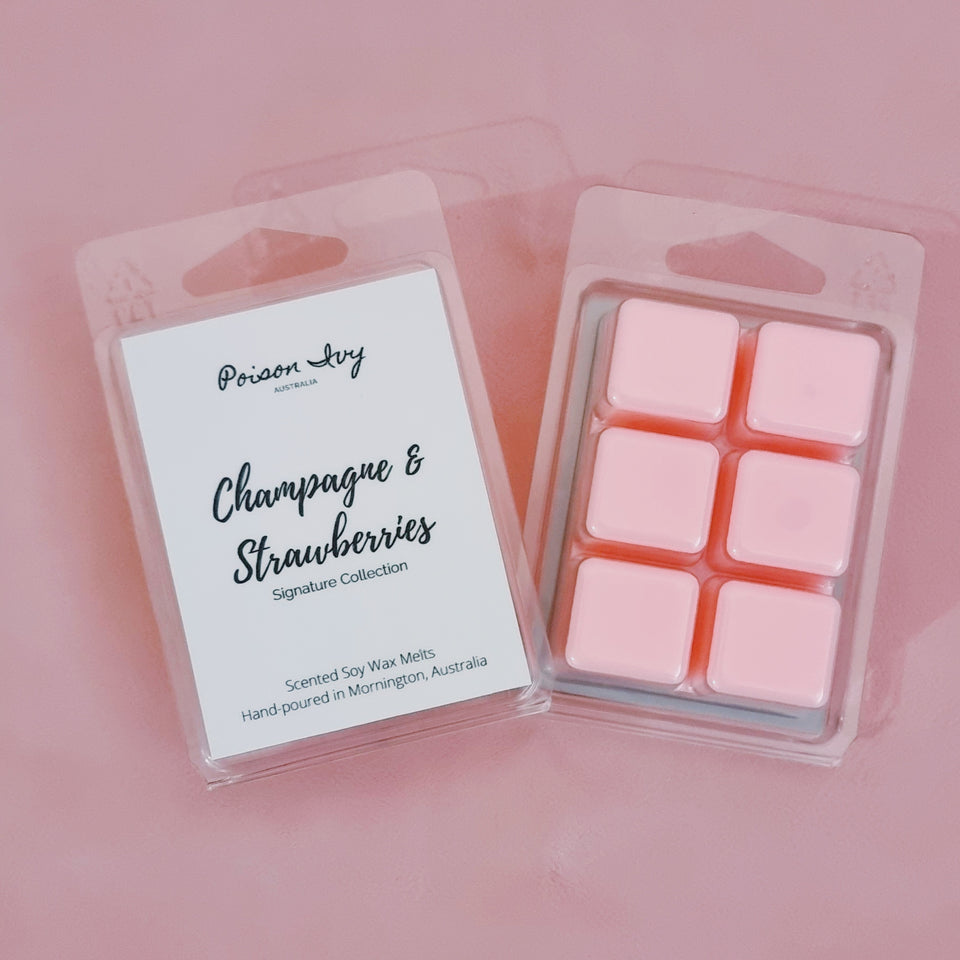 Two packs of soy wax melts. The pack on the left shows the label which lists the fragrance as Champagne and Strawberries. The pack on the right is face down to show what the wax melts look like. They look like six pink wax cubes.